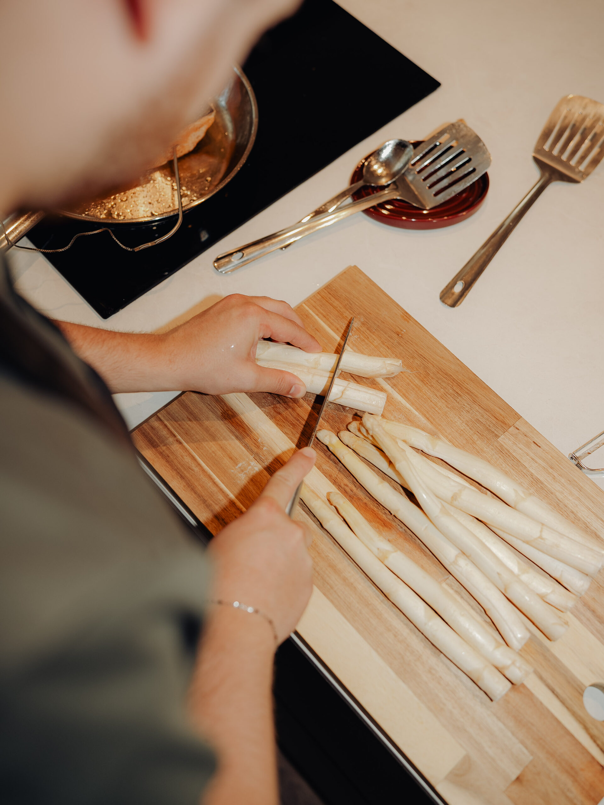 Witte asperges worden gesneden op een houten plank