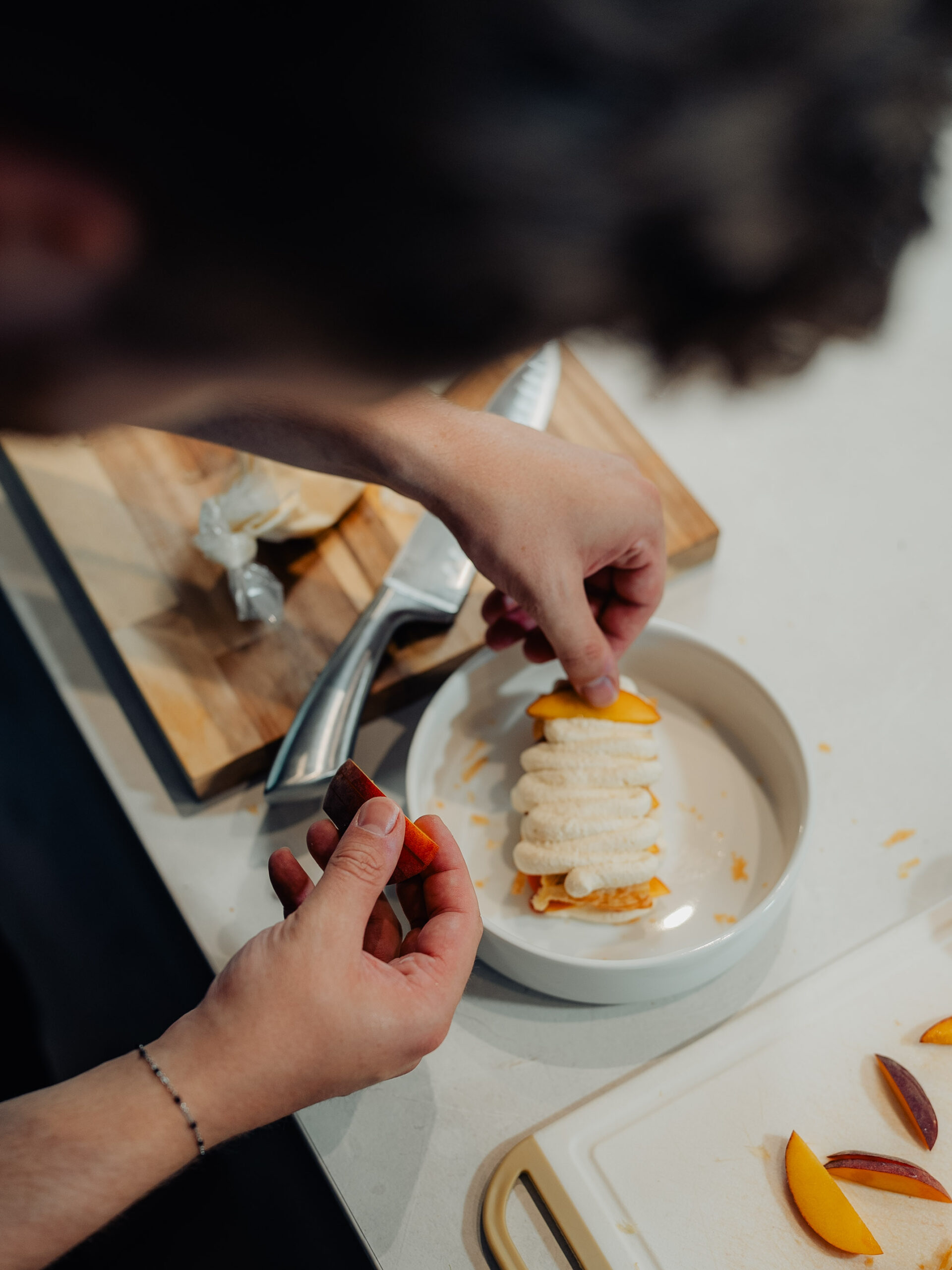 Dessert met perzik en room wordt opgemaakt